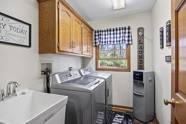 washroom featuring sink, washing machine and clothes dryer, and cabinets