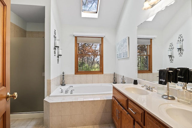 bathroom with vanity, tile patterned floors, lofted ceiling with skylight, and independent shower and bath