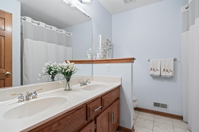 bathroom featuring vanity, tile patterned floors, and toilet