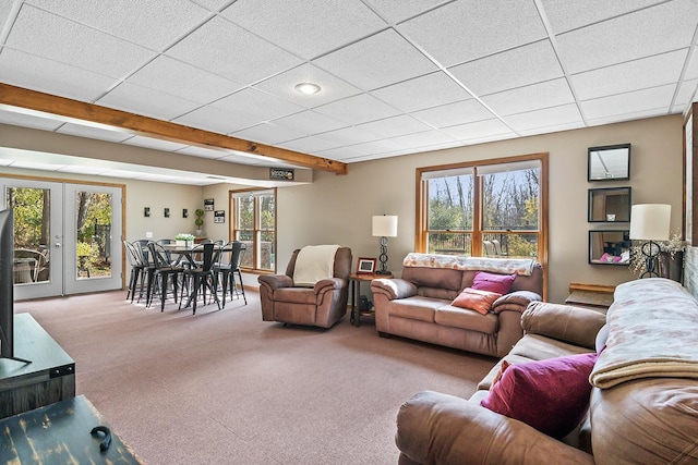 carpeted living room with french doors and a drop ceiling