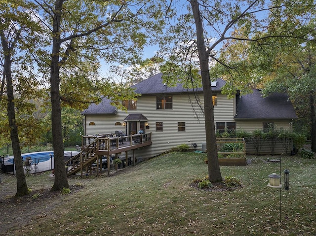 back of house featuring a swimming pool side deck and a yard