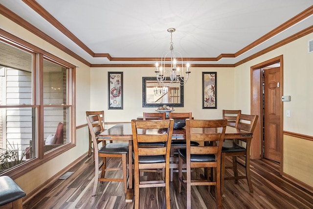 dining room featuring dark hardwood / wood-style flooring, a chandelier, ornamental molding, and plenty of natural light