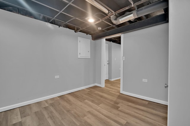 basement with electric panel and hardwood / wood-style flooring