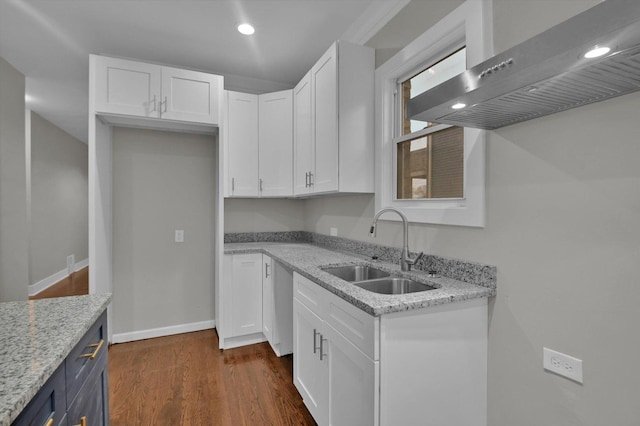 kitchen featuring light stone counters, sink, white cabinets, and exhaust hood