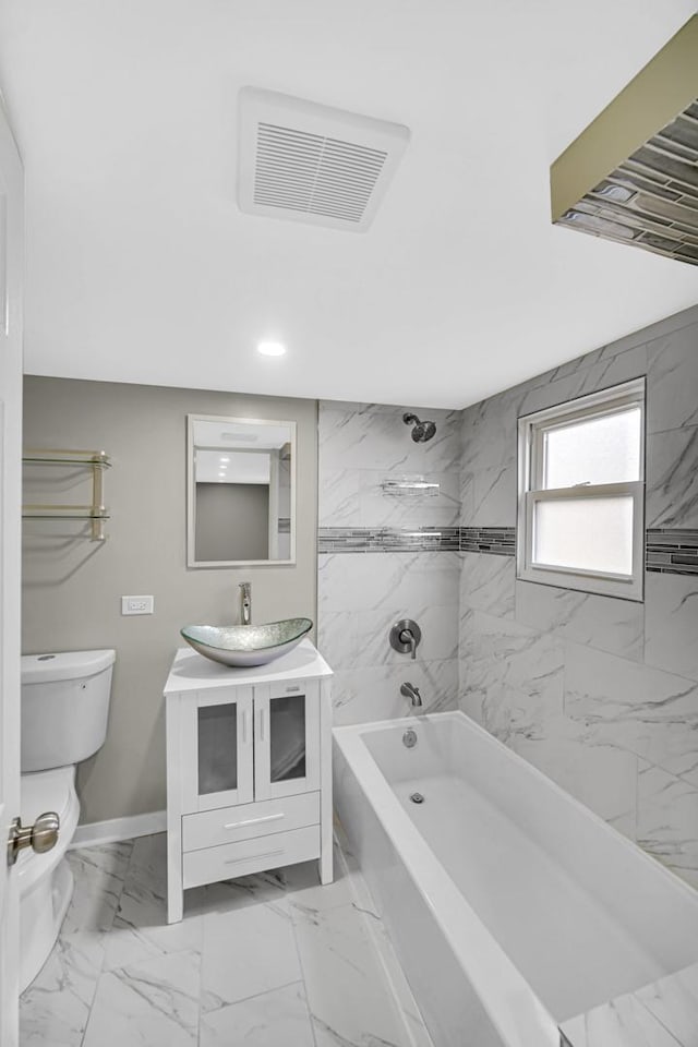 full bathroom with vanity, tiled shower / bath combo, and toilet