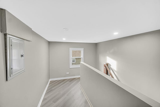 hallway featuring light wood-type flooring and electric panel