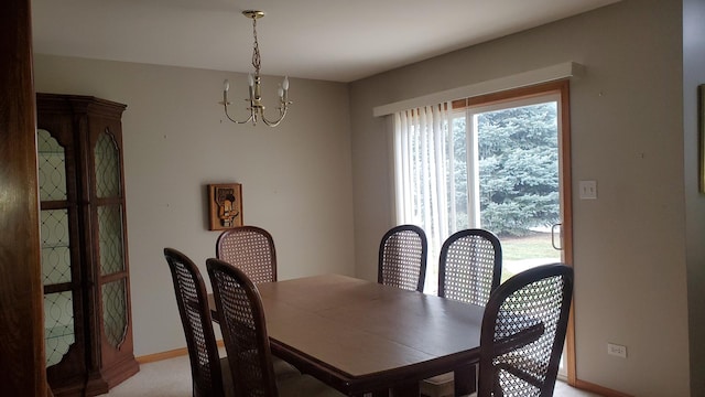 dining room featuring light carpet and a chandelier