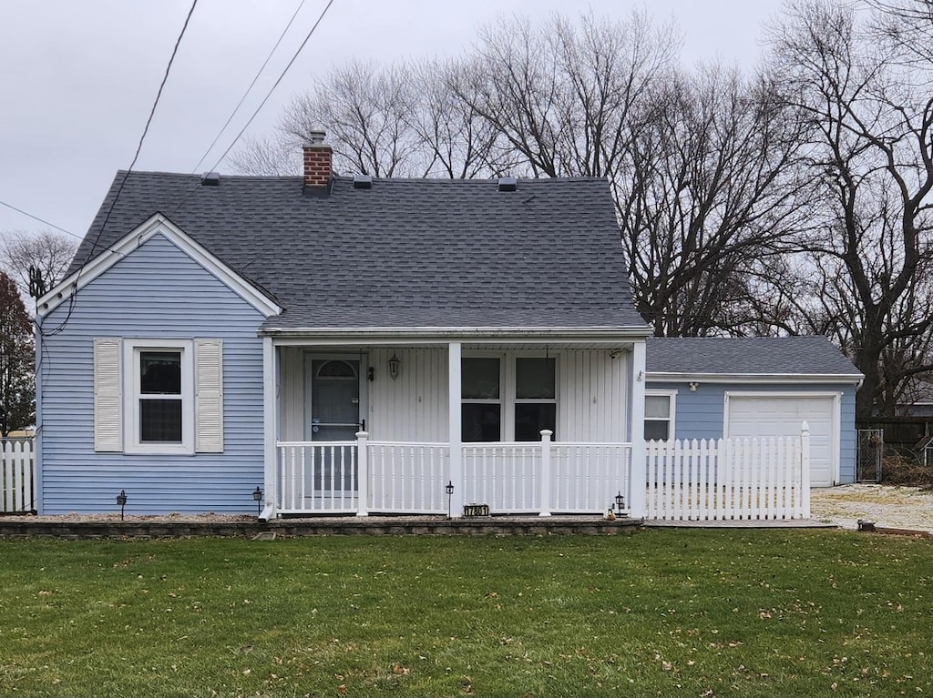 view of front of property with covered porch, a garage, and a front yard