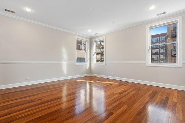 unfurnished room with hardwood / wood-style flooring and ornamental molding