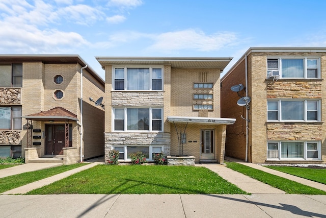 townhome / multi-family property featuring a front lawn