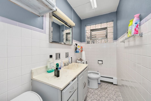 bathroom featuring vanity, toilet, tile walls, and a baseboard heating unit