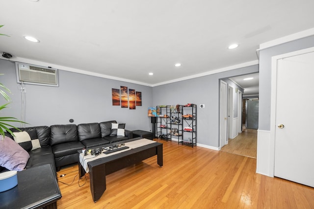 living room with crown molding, a wall mounted air conditioner, and light wood-type flooring