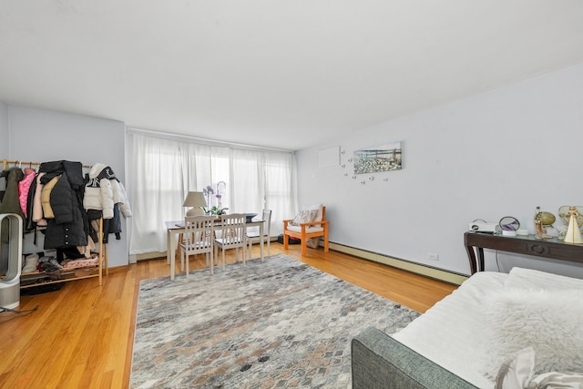 bedroom featuring wood-type flooring and a baseboard heating unit