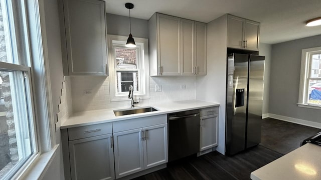 kitchen with decorative light fixtures, dark hardwood / wood-style flooring, stainless steel appliances, and tasteful backsplash