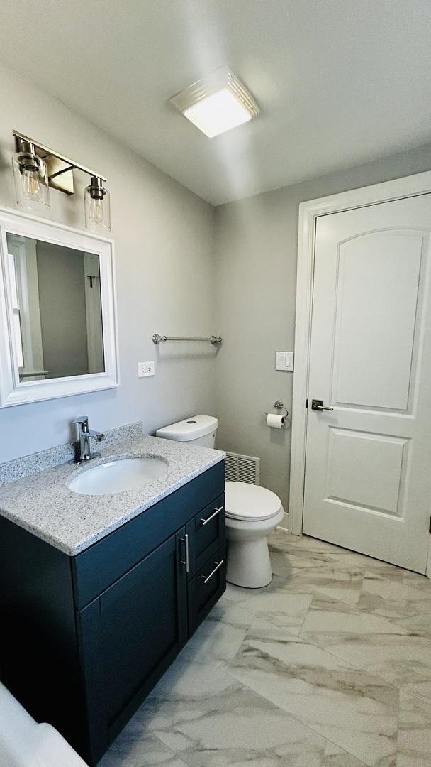 bathroom featuring vanity and toilet