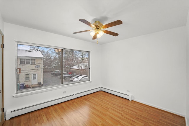 spare room with hardwood / wood-style floors, ceiling fan, and baseboard heating