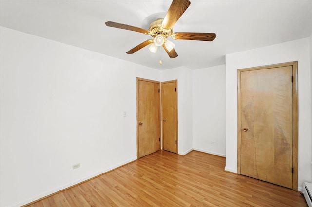 unfurnished bedroom featuring ceiling fan, light hardwood / wood-style floors, and a baseboard heating unit