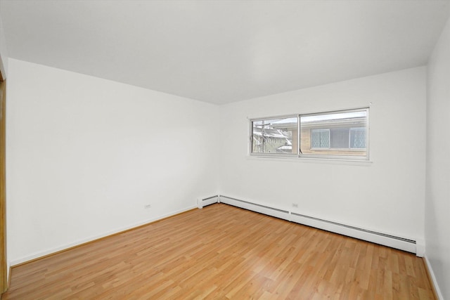 spare room featuring light hardwood / wood-style floors and a baseboard heating unit