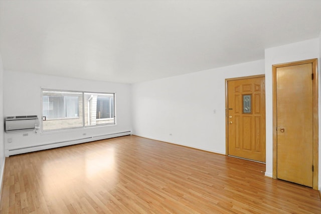 unfurnished room featuring light hardwood / wood-style flooring, a wall mounted AC, and a baseboard heating unit