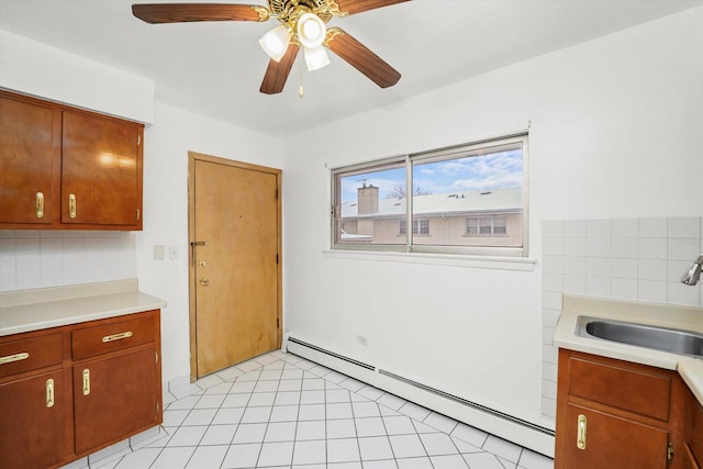 kitchen featuring ceiling fan, light tile patterned flooring, sink, and baseboard heating