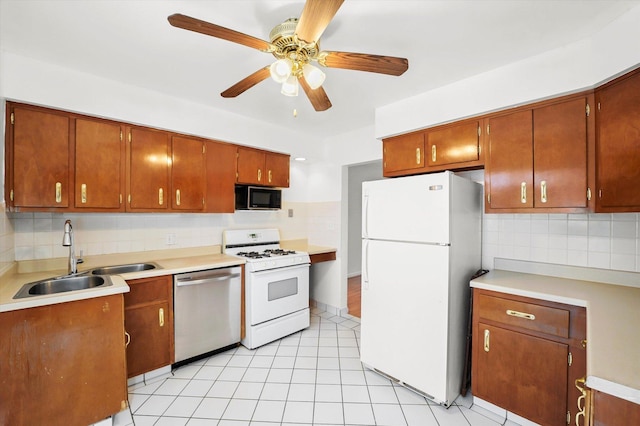 kitchen featuring ceiling fan, sink, white appliances, decorative backsplash, and light tile patterned floors