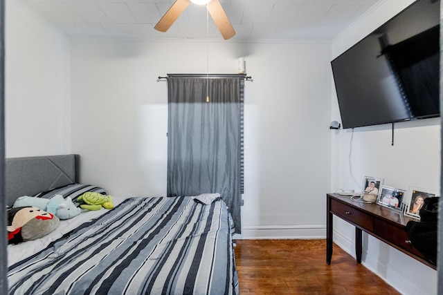 bedroom featuring dark hardwood / wood-style flooring, ceiling fan, and crown molding