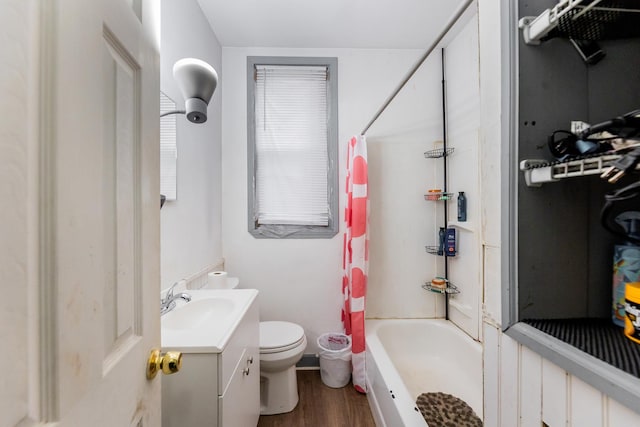 full bathroom featuring hardwood / wood-style floors, vanity, shower / tub combo, and toilet