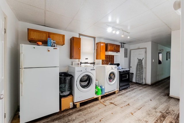 washroom featuring rail lighting, light hardwood / wood-style flooring, and washing machine and clothes dryer