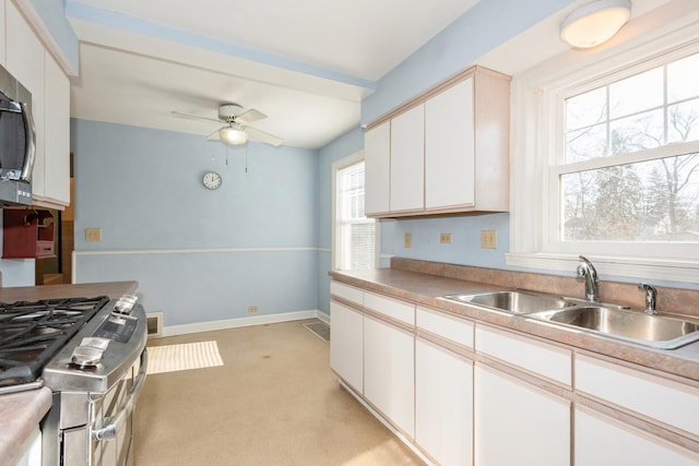 kitchen with sink, ceiling fan, white cabinetry, and appliances with stainless steel finishes