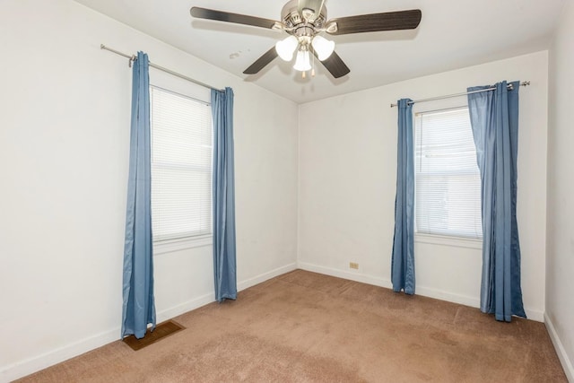 carpeted spare room featuring ceiling fan