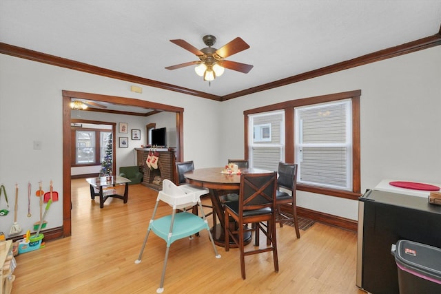 dining space with ceiling fan, ornamental molding, and light wood-type flooring