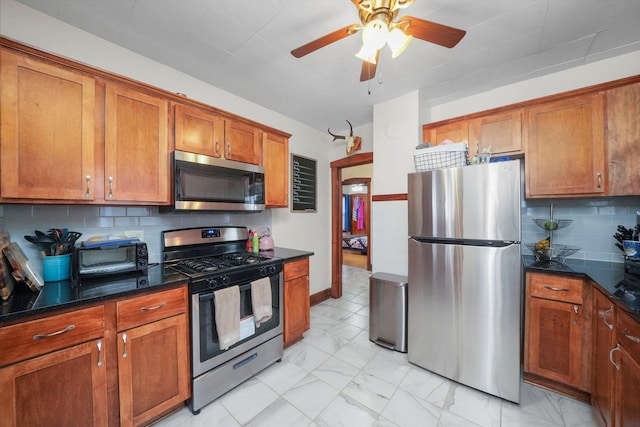 kitchen with decorative backsplash, stainless steel appliances, and ceiling fan