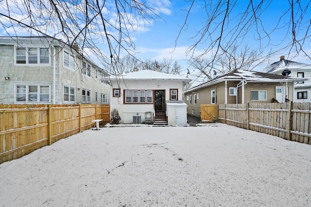 snow covered property with central AC unit