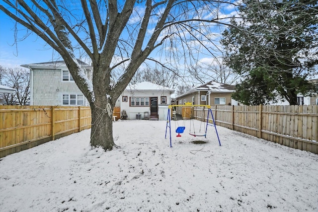 yard layered in snow featuring a playground