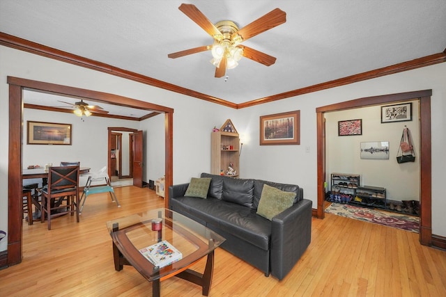 living room featuring a textured ceiling, light hardwood / wood-style flooring, and ornamental molding