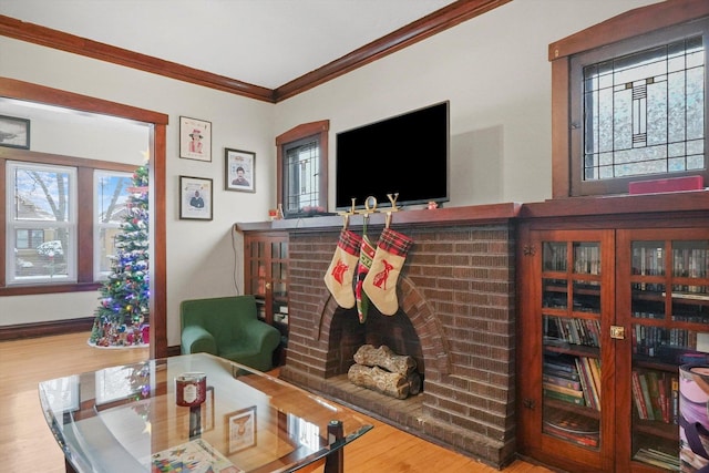 living room featuring hardwood / wood-style floors, a brick fireplace, and ornamental molding