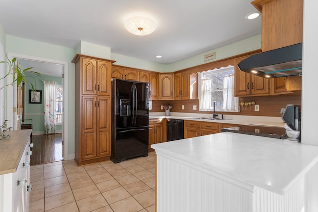 kitchen featuring black appliances, range hood, sink, and light tile patterned flooring