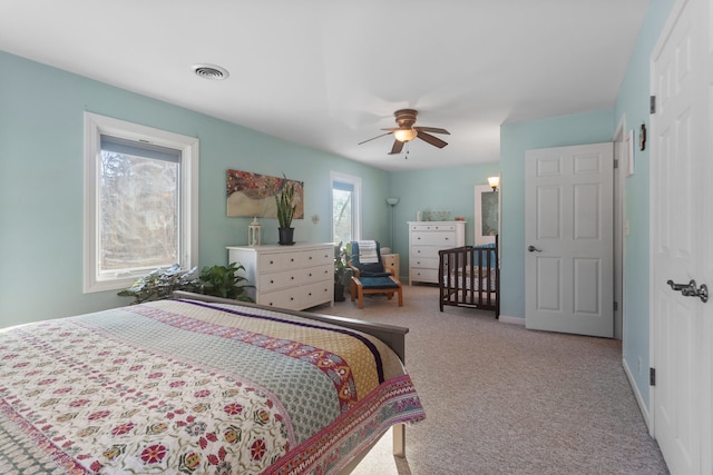 carpeted bedroom with ceiling fan and multiple windows