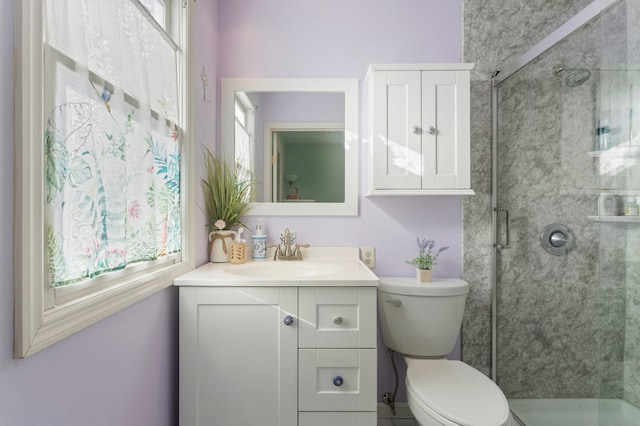 bathroom with toilet, an enclosed shower, and vanity