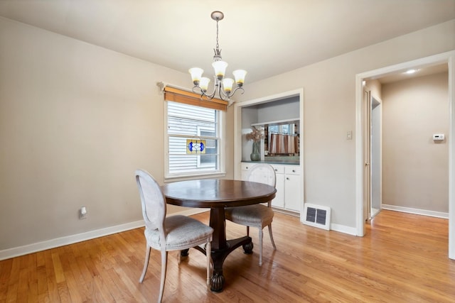 dining room featuring light hardwood / wood-style flooring and an inviting chandelier