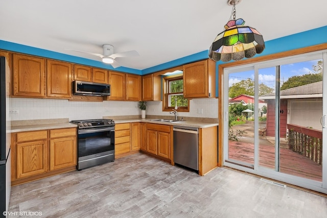 kitchen featuring ceiling fan, light hardwood / wood-style floors, sink, hanging light fixtures, and stainless steel appliances