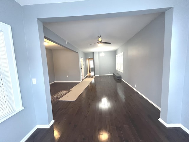 unfurnished room with ceiling fan and dark wood-type flooring