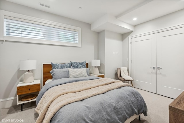 bedroom featuring light carpet and a closet