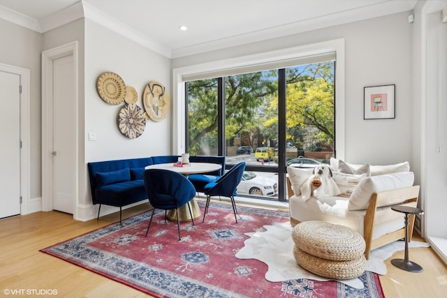 living area with crown molding and hardwood / wood-style floors