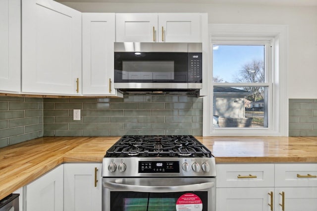 kitchen with decorative backsplash, white cabinetry, wooden counters, and stainless steel appliances