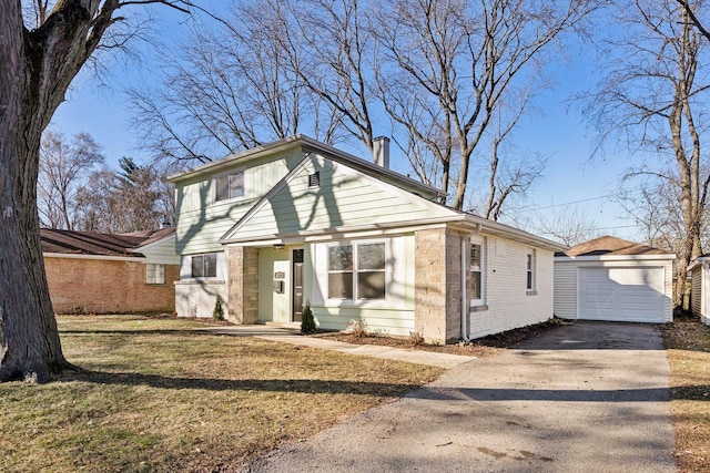 view of front of house featuring an outbuilding, a garage, and a front yard