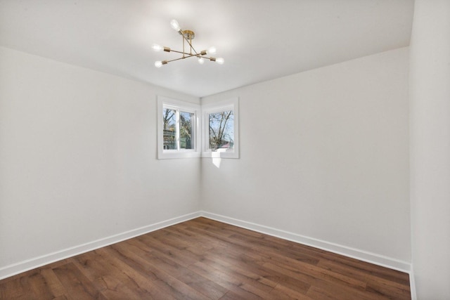 unfurnished room with dark hardwood / wood-style flooring and an inviting chandelier