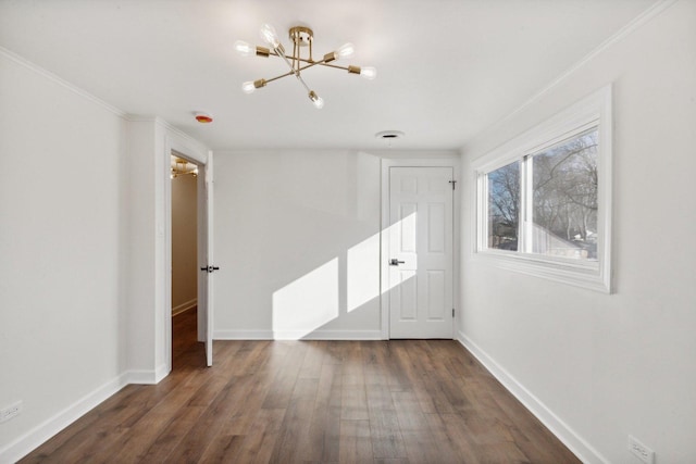 unfurnished room with a notable chandelier, dark hardwood / wood-style flooring, and crown molding