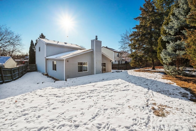 view of snow covered back of property