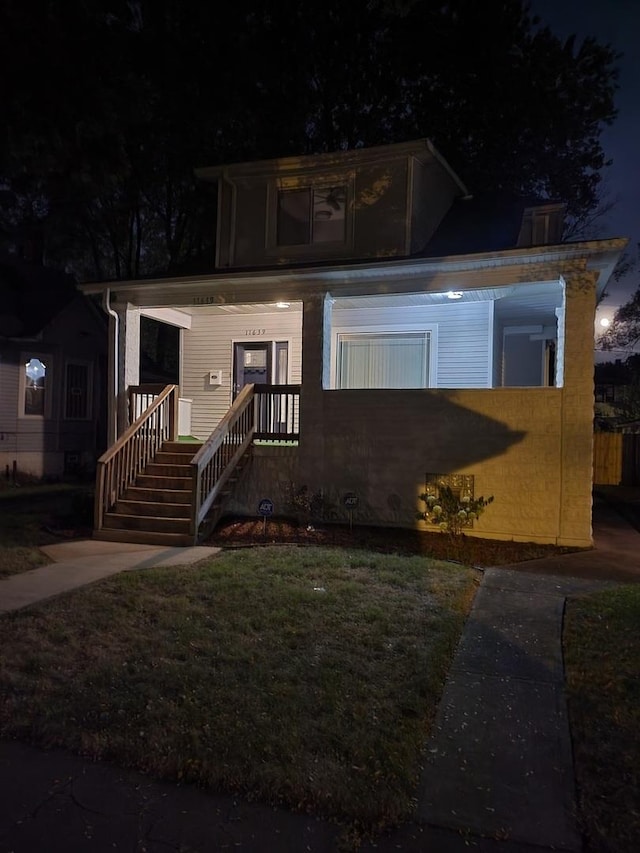 view of front of house with a porch and a yard